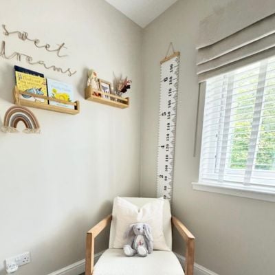 a beige roman blind fitted over a white taped wooden blind