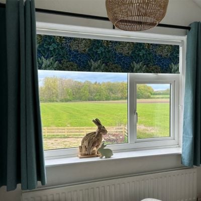 Dark blue and green floral roller blind paired with teal curtains