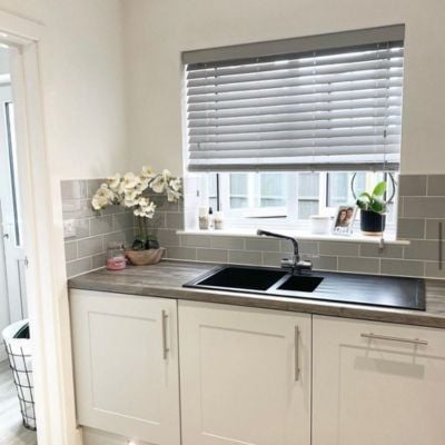 Grey, wooden Venetian blinds in a kitchen window