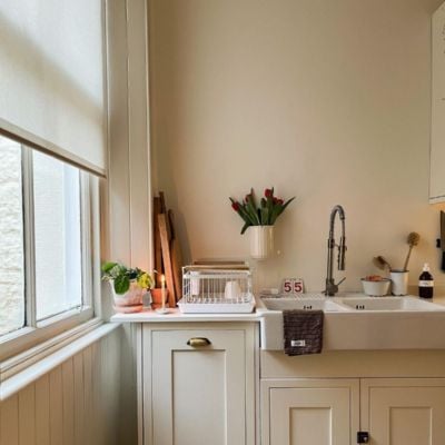 Light-filtering, sheer beige roller blind in a neutral kitchen