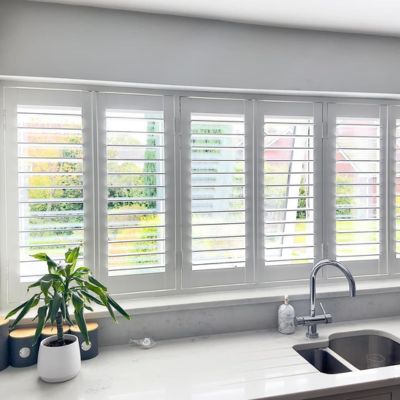 White, fitted shutters in a kitchen window